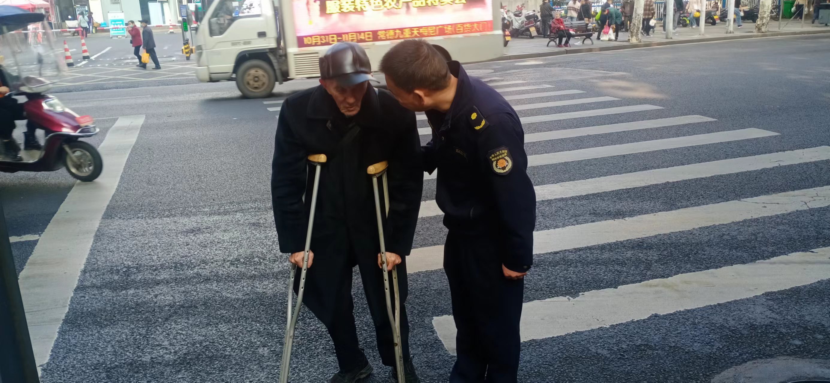 武陵区城管局府坪中队队员搀扶老人过马路 平凡举动温暖人心
