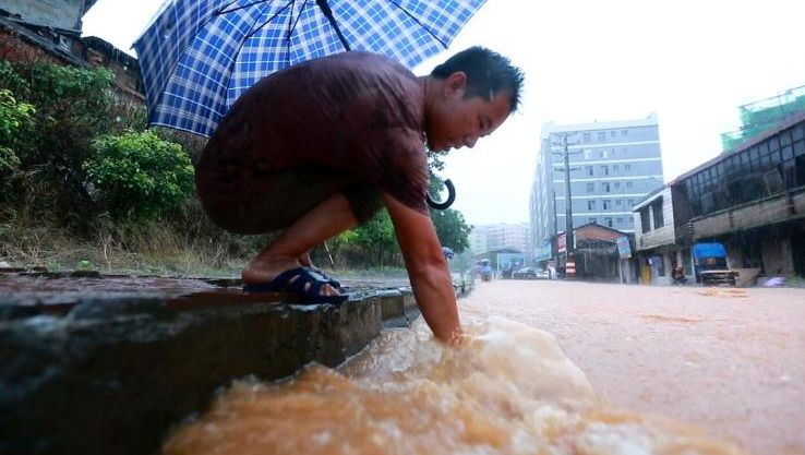 市民徒手疏通下水管口  确保道路畅通